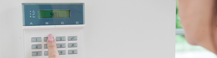 woman pressing a security system panel